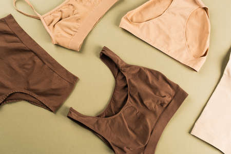 Top view of brown and beige cotton underwear on green backgroundの写真素材