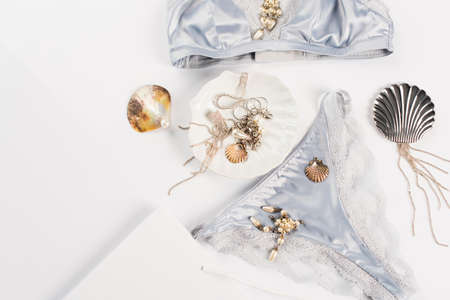 Top view of shopping bag near silk lingerie and accessories on white backgroundの写真素材