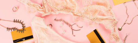 Top view of credit cards, lace lingerie and golden accessories on pink background, bannerの写真素材
