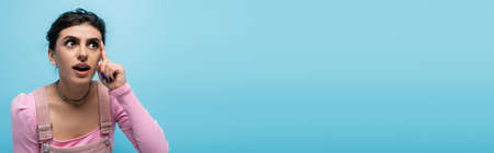 amazed woman with open mouth having idea isolated on blue, bannerの写真素材