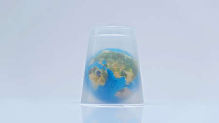 globe covered with plastic cup on greyの写真素材
