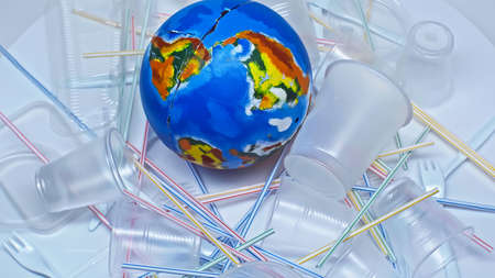 globe near plastic cups and trash on white