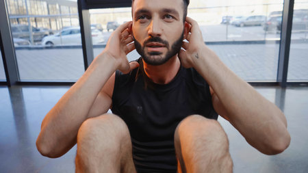 Athletic sportsman doing sit ups while training in gymの写真素材