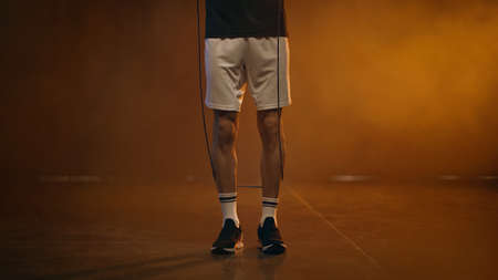 Cropped view of sportsman holding jump rope on dark backgroundの写真素材