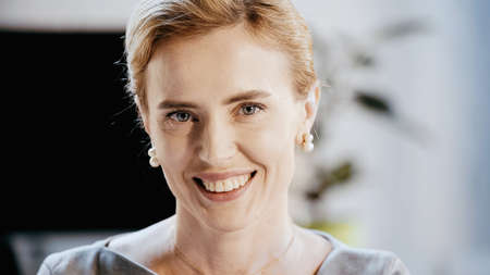 Cheerful businesswoman looking at camera in office