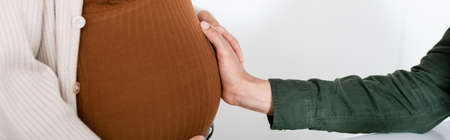 cropped view of african american man touching belly of pregnant wife, banner