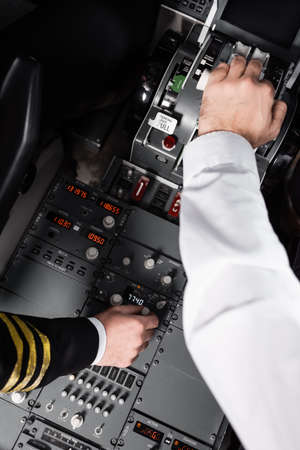 top view of pilots using control panel and thrust lever in airplaneの写真素材