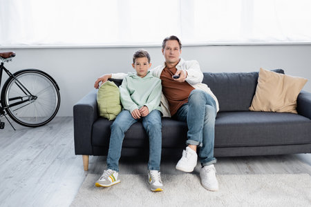 Family watching tv on couch in living roomの写真素材