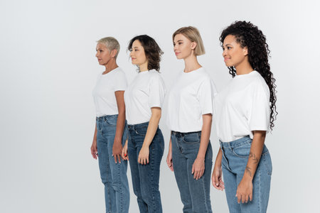 Interracial women in white t-shirts looking away isolated on grey, feminism conceptの写真素材