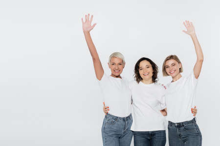 Smiling women in white t-shirts waving hands isolated on grey, feminism conceptの写真素材
