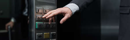 cropped view of man pressing button in modern elevator, banner