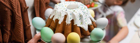 delicious easter cake and painted eggs near cropped family, bannerの写真素材