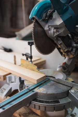 Close up view of miter saw and wooden board in workshopの写真素材