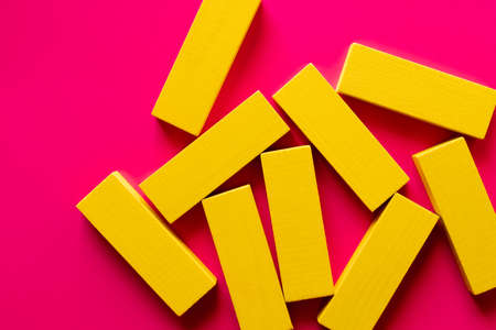 top view of several yellow blocks on bright pink backgroundの写真素材