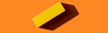 top view of yellow rectangular block on orange background with shadow, bannerの写真素材