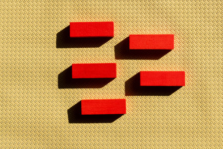 top view of bright red blocks on beige textured background