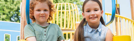 happy brother and sister looking at camera in amusement park, bannerの写真素材