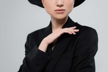 cropped view of young woman with perfect skin, wearing black blazer isolated on greyの写真素材