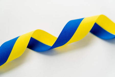 Close up view of curly blue and yellow ribbon on white backgroundの写真素材