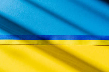 Top view of blue and yellow ribbon on ukrainian flag with shadowの写真素材