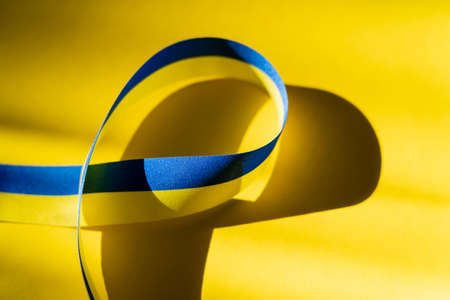 Close up view of blue and yellow ribbon on background with shadowの写真素材