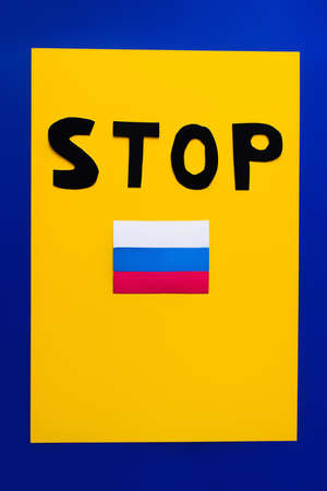 Top view of stop lettering and russian flag on blue and yellow background