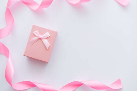 top view of gift box near ribbon on whiteの写真素材