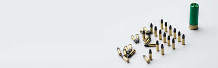 same caliber bullets near shotgun shell on white, bannerの写真素材