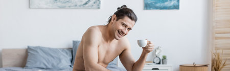 happy and shirtless man with long hair holding cup of coffee, bannerの写真素材