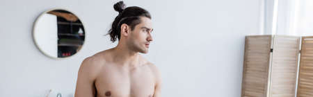 shirtless man with long hair in modern bathroom, bannerの写真素材