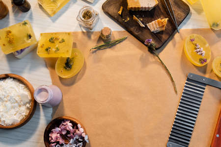 Top view of handmade soap bars with dry flowers and supplies on craft paperの写真素材