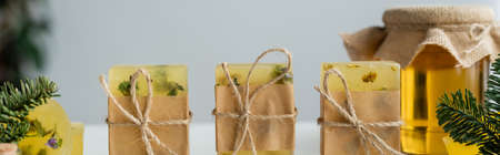 Craft soap bars with twine near jar with honey and spruce branches, bannerの写真素材