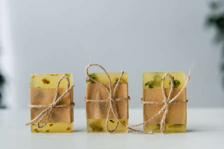 Close up view of handmade soap bars with craft paper and twine on tableの写真素材