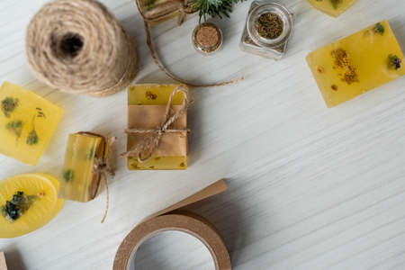 Top view of craft soap bars with flowers and twine on tableの写真素材
