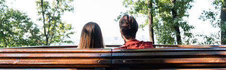 Back view of couple of tourists sitting on bench in city, bannerの写真素材