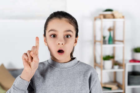 amazed girl looking at camera and showing idea gestureの写真素材