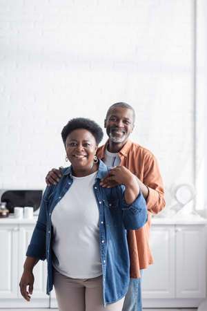 happy and senior african american man hugging cheerful wifeの写真素材