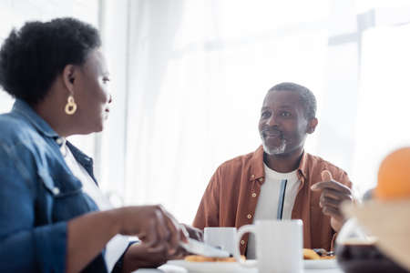 senior african american man talking with wife during breakfastの写真素材