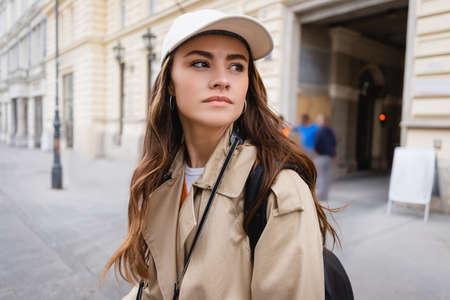 pretty woman in trench coat and baseball cap