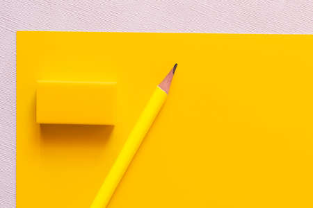 top view of pencil near eraser on yellow and white