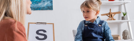 Kid looking at blurred speech therapist with letter on clipboard in consulting room, banner