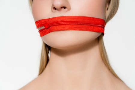 Cropped view of woman with red zipper on mouth isolated on greyの写真素材