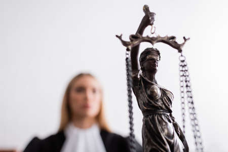 selective focus of themis statue near prosecutor on blurred backgroundの写真素材