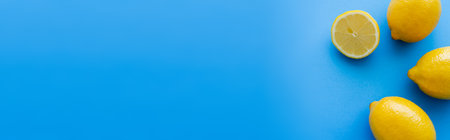 Top view of bright lemons on blue background, bannerの写真素材
