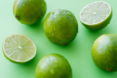Close up view of ripe limes with water drops on green backgroundの写真素材