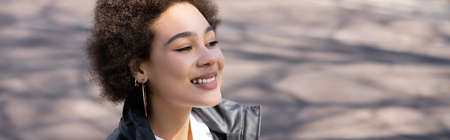 sunshine on face of positive african american woman in jacket, bannerの写真素材