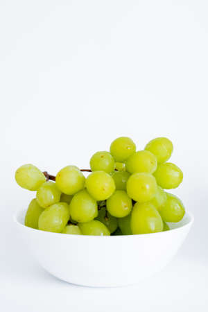 sweet green grapes in bowl on whiteの写真素材
