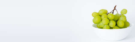 fresh and green grapes in bowl on white, bannerの写真素材