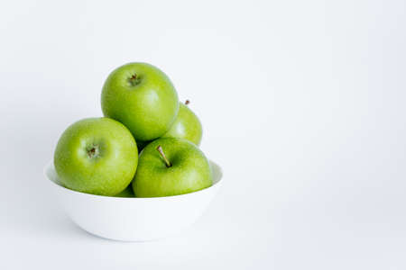 bowl with green and ripe apples on whiteの写真素材