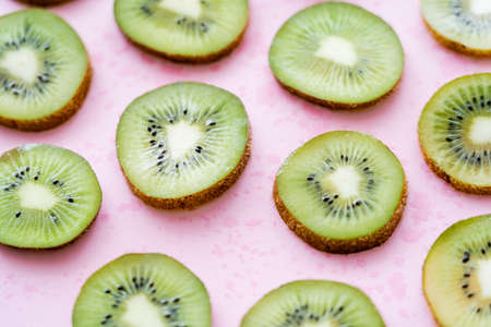 close up view of sliced fresh kiwi on pinkの写真素材